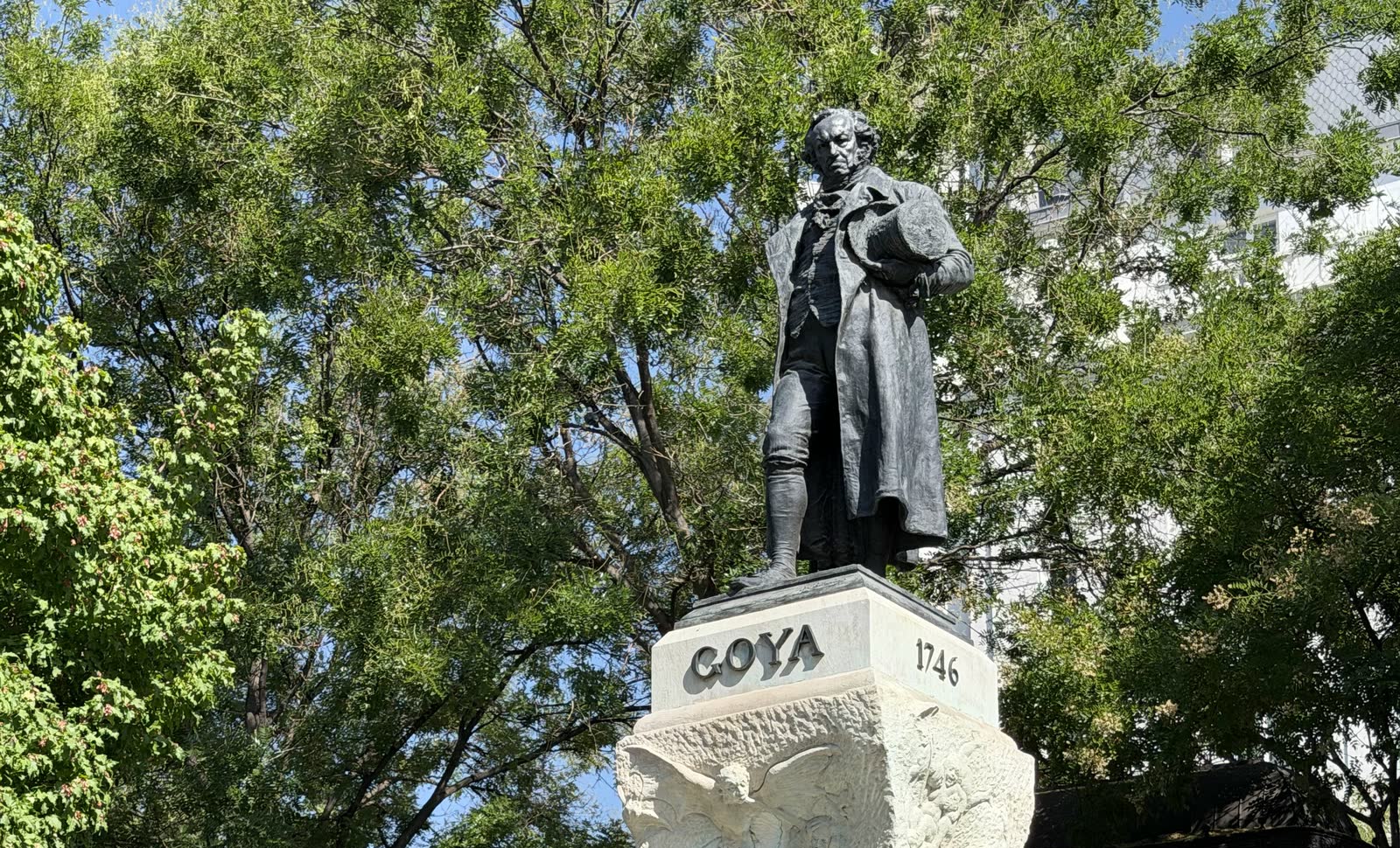 Monument to Francisco Goya framed by trees outside the Prado Museum in Madrid
