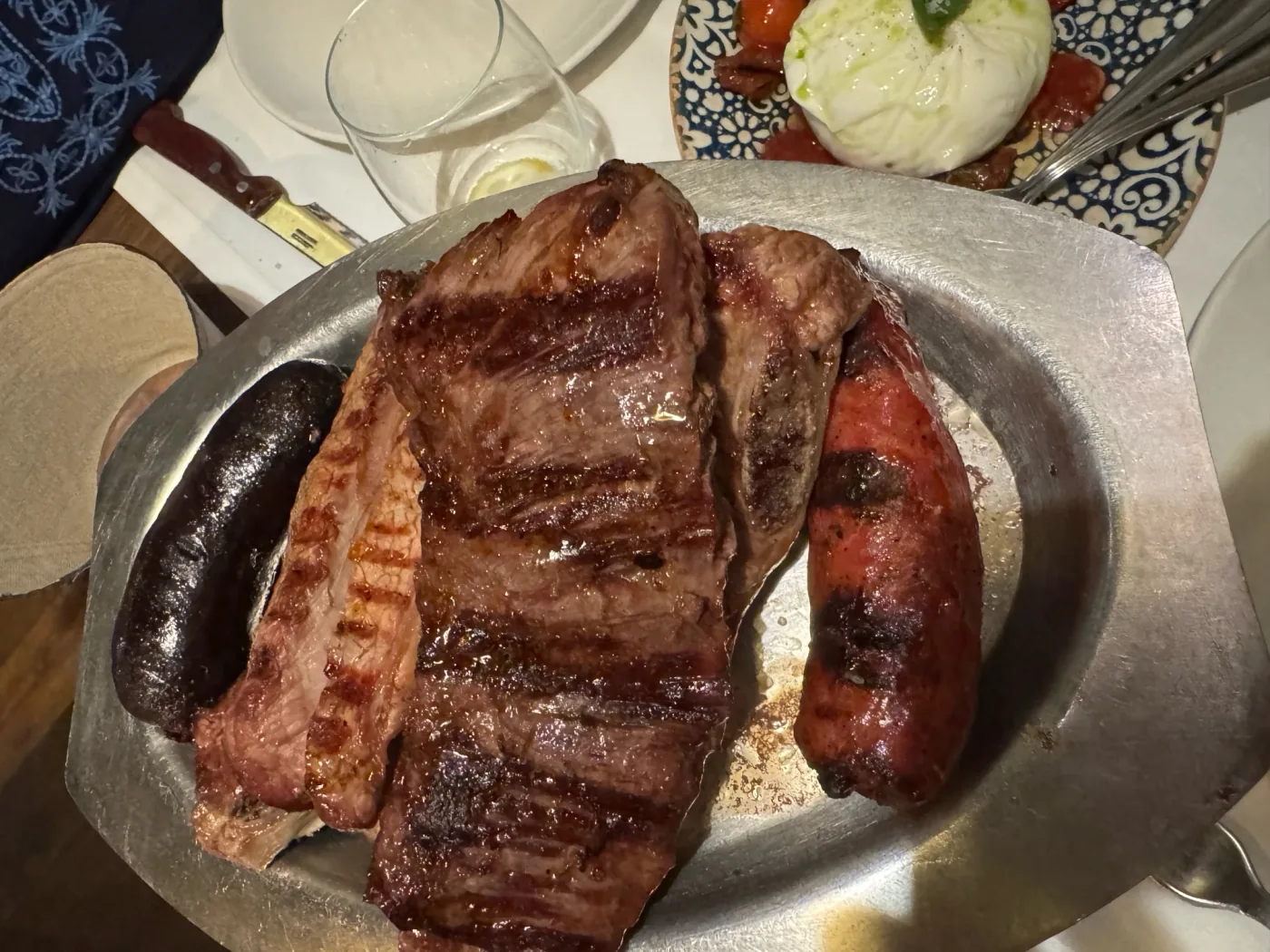 Mixed grilled meats and sausages served on a metal platter