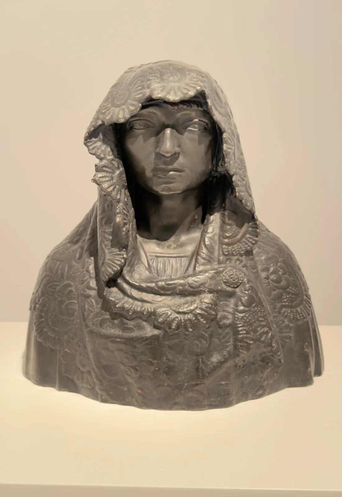 Dark sculpted portrait with a silver headdress displayed at the Reina Sofía Museum